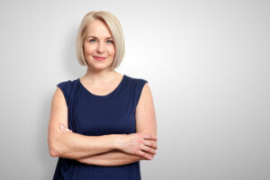 Woman with arms crossed grey background