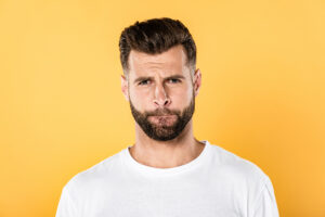 Man grimacing yellow background