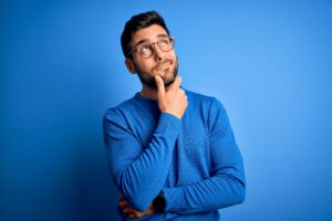 Young man holding chin in thought