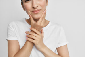 Woman in white shirt holding mouth