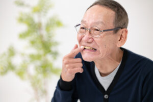 Man pointing finger to tooth