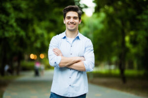 Thoughtful casual man outdoors looking up and smiling