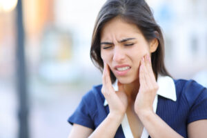 Woman holding face in pain